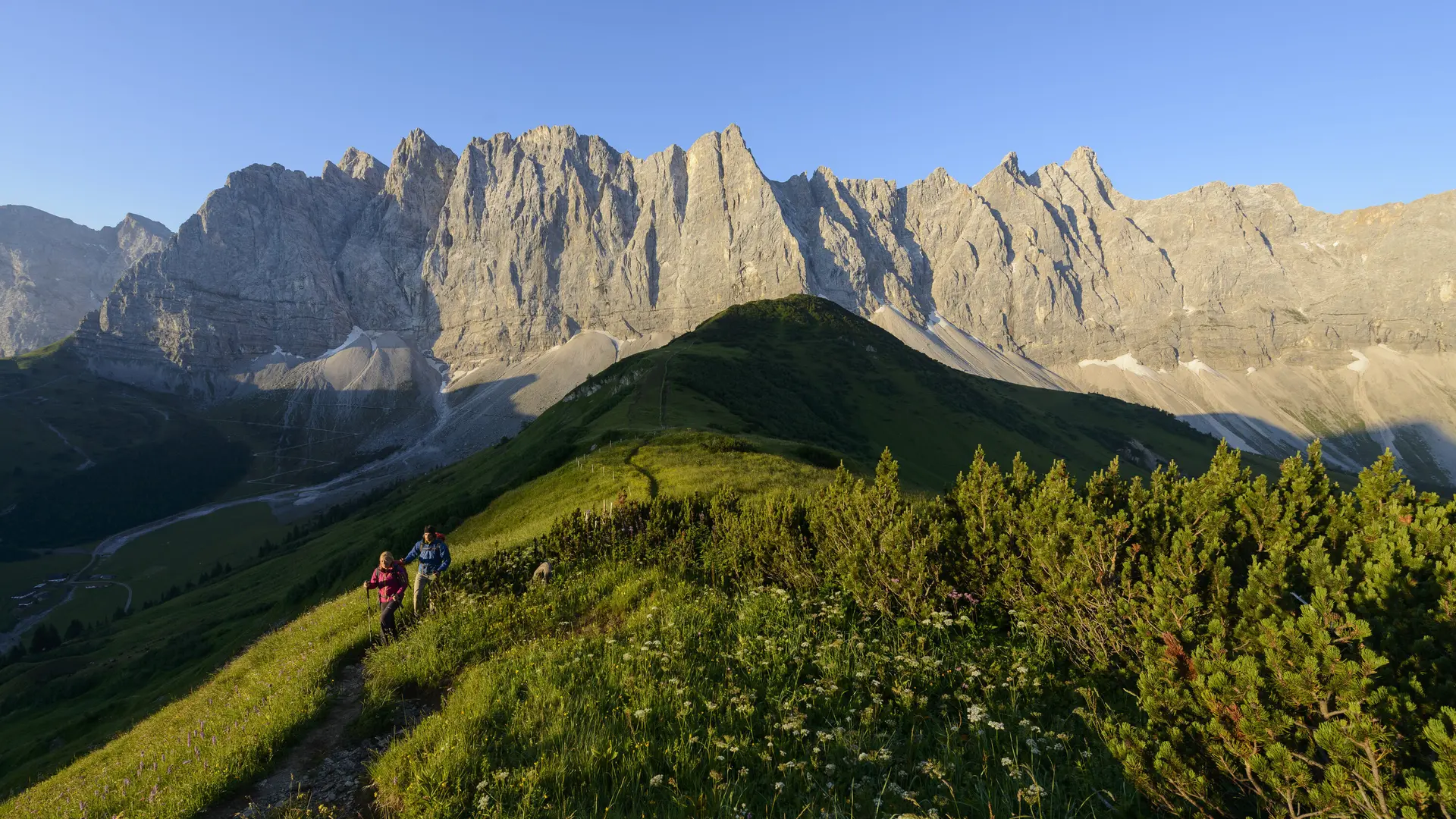 Panoramaaufname von Berggipfeln mit zwei Wanderern | © DAV/Wolfgang Ehn